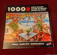 Front of puzzle box showing seaside cafe image and puzzle piece count (1000 pieces).