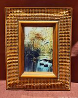 Front view showing the 8 x 10 inch basket-weave textured wooden frame encasing the 3.5 x 5.5 woodland portrait print with river and autumn trees.