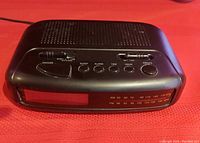 Front angled view of the clock radio showing the LED time display window and front control buttons.