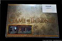 Sealed Game of Thrones collector box front with gold lettering and decorative background