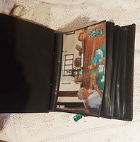 Open album showing color photo inside a black plastic sleeve, illustrating photo size and album capacity.