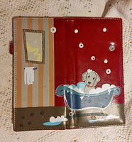 Wallet open view showing hand painted dog in bathtub, bathroom mirror, towel and paw prints on the interior and exterior sections.