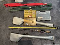 Full lot overview showing two vinyl fishing rod carrying cases, grey fabric rod holders, fishing rod, and tackle boxes with lures.
