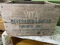 Front view of wooden crate showing 'VITA Beverages Limited Toronto, Ont. Bottles & Boxes Must Be Returned' stencil text.