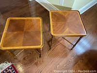 Overhead view of two square vintage walnut wood side tables with brass castor wheels.