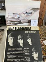 Front covers of Beastie Boys License to Ill and Beatles Beatlemania vinyl albums stacked together.