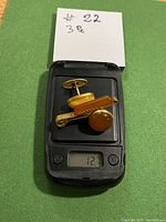 3 piece vintage amber and 9 kt gold accessories set on a scale showing total weight of 12.7 grams