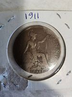 Front side of the 1911 British penny showing Britannia seated with trident and shield.