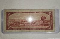 Back side of the Canadian 2 dollar bill showing landscape scene and denomination.
