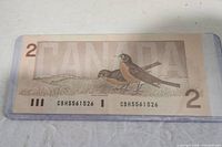 Reverse side of the 1986 Canadian two dollar bill featuring two robins and large Canada text.