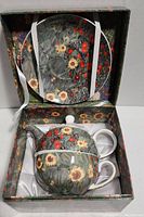 Tea set with teacup, saucer, and teapot in a decorated box featuring floral patterns