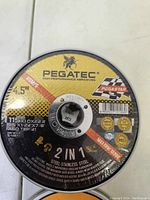 Close-up of Pegatec branded cutting wheels with details on size, RPM and materials suitable for cutting steel and stainless steel.