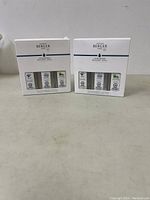 Two boxes of Maison Berger Lampe Berger replacement fragrance refill bottles, unopened, showing front package design and brand labels.