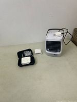 Overview of all items on table including Max Fill cooling cube, multi USB plug, and 3-in-1 charging station with accessories