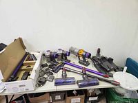 Overview of box with wand tubes, brush heads, chargers and motor bodies on tabletop