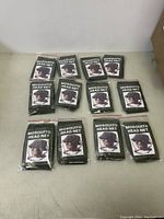 Lot of 12 new mosquito head nets, individually packed and labeled, arranged on floor.