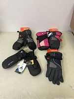 Four pairs of youth gloves and mittens, 3 Kombi brand and 1 Auclair brand, all new with tags.
