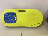 Full view of the yellow compact badminton set case with a handle and the Solognac label. Case shows a crack at the front corner.