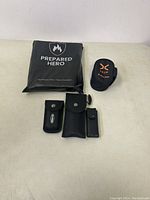 All items arranged on a flat surface showing fire blanket pouch and three multi-tool holders.