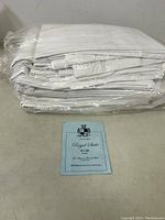 Stack of six folded and sealed white sheets with a blue label in front displaying size and branding.