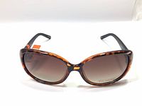 Front view showing oversized oval gradient brown lenses with leopard print frame and black temples.