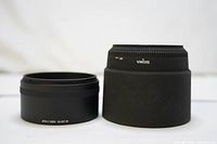Front view of two Sigma lens hoods, smaller HA 927-01 adapter on left and larger cylindrical hood on right