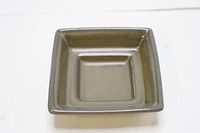 Square ceramic plate with smooth brown glaze and slight indentation for holding items