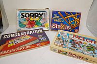 Four board games including Sorry!, Staxis, Concentration, Face Off in original boxes showing wear and condition