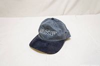 Full view of blue and dark blue unisex baseball cap with SKF knitted letters on the front.