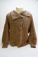 Front view of marled brown cable knit cardigan with large collar and double-breasted button closure