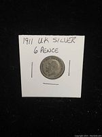 Photo of the front (obverse) of the 1911 UK silver 6 pence coin showing King George V's profile and handwritten note.