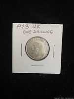 Front side of the 1923 UK silver one shilling coin showing King George V portrait and handwritten label.