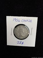 Front side of the 1956 Canadian silver quarter coin showing the profile of Queen Elizabeth II inside a protective holder with handwritten note.