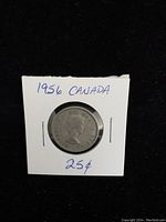 Obverse side of 1956 Canada silver quarter showing Queen Elizabeth II profile in a cardboard holder labeled '1956 CANADA 25¢'.