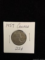 Obverse side of the 1957 Canadian silver quarter showing Queen Elizabeth II's profile in a protective holder.