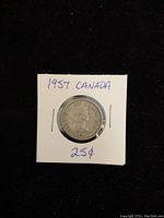 Photo of the obverse side of the 1957 Canadian silver quarter showing Queen Elizabeth II's profile with handwritten labels on holder.