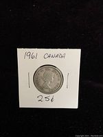 Obverse side of 1961 Canadian silver quarter showing Queen Elizabeth II profile with inscriptions and coin details.