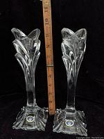 Pair of Poltar 24% lead crystal candle holders standing side by side against black background, showing height with measuring stick.
