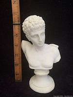 Full front view of the white alabaster Hermes bust statue with ruler showing size approximately 6.5 inches tall.