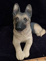 Close frontal view of the German Shepherd dog figurine showing facial details including ears, eyes, nose, and mouth.