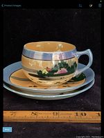 Side view of teacup and saucers with measuring ruler showing dimensions