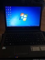 Acer laptop powered on showing Windows 7 Ultimate desktop screen with various icons.