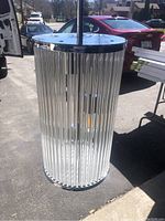Clear view of the cylindrical hallway lantern showing the vertical glass rods and chrome top.