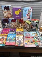 Photo showing an array of Scholastic books including Bone series graphic novels, Baby-Sitters Club, Guts, The Witches, Monster, and Captain Underpants, displayed on a gray background.