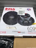 Photo of BOSS Audio Systems CXX8 subwoofer in original box with product information and power rating visible.