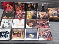 Photo showing 12 CDs arranged, including Celine Dion, Elton John, jazz, and relaxing music collections.