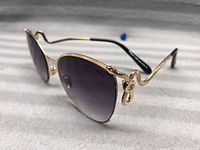 Side angle showing gold-tone frame with snake detail and gradient lenses