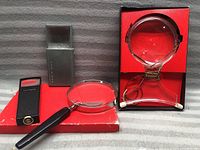 Overall view of the four magnifiers including the Hoffritz neck magnifier with original box and three other magnifiers