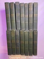 Front view of 14 hardcover books by Rudyard Kipling in green covers with gold embossed text on spines.