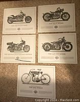 Set of 5 Harley-Davidson motorcycle prints laid out on the floor, each featuring a different historic model with text description beneath the image.